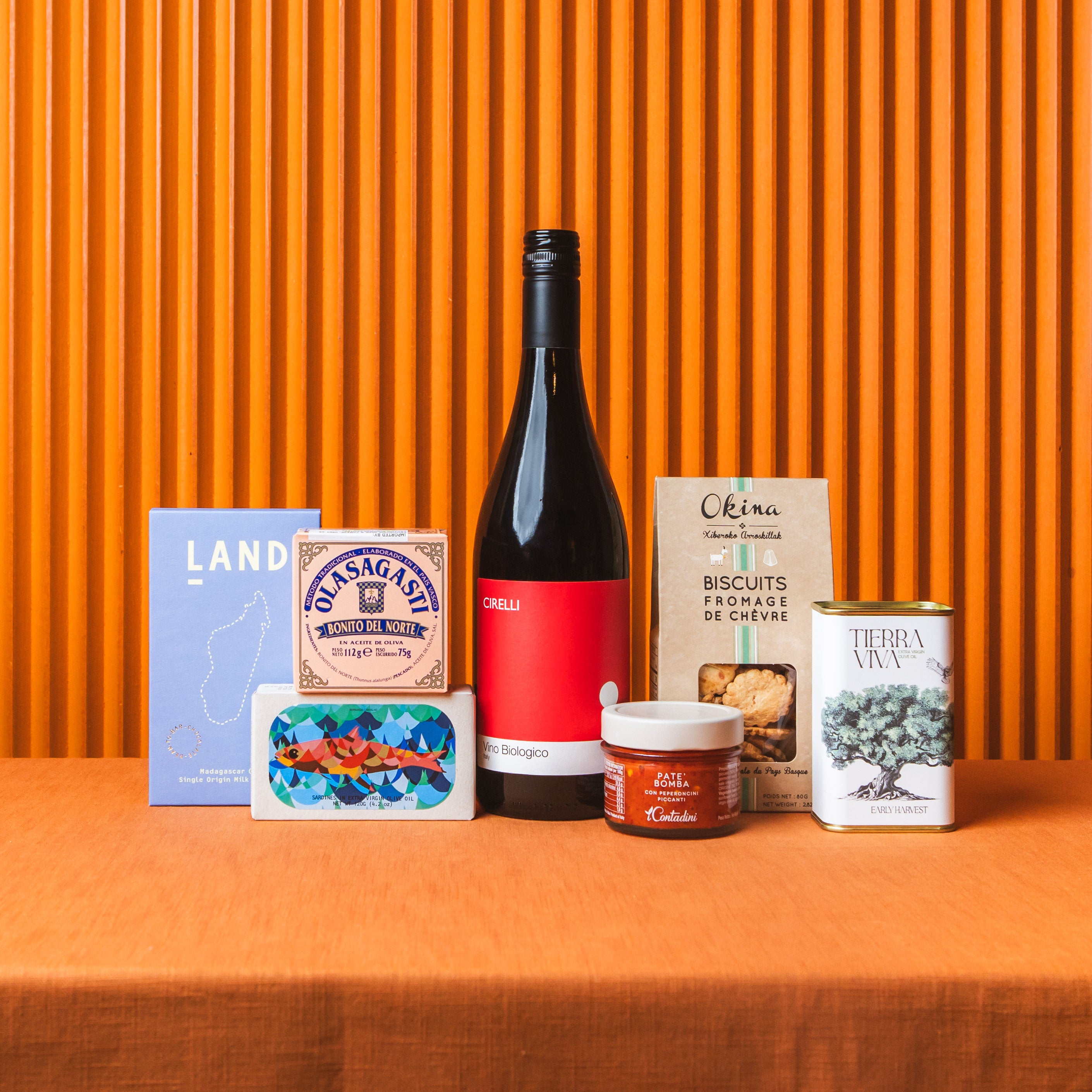 Collection of products including a bottle, jars, and boxes on an orange background